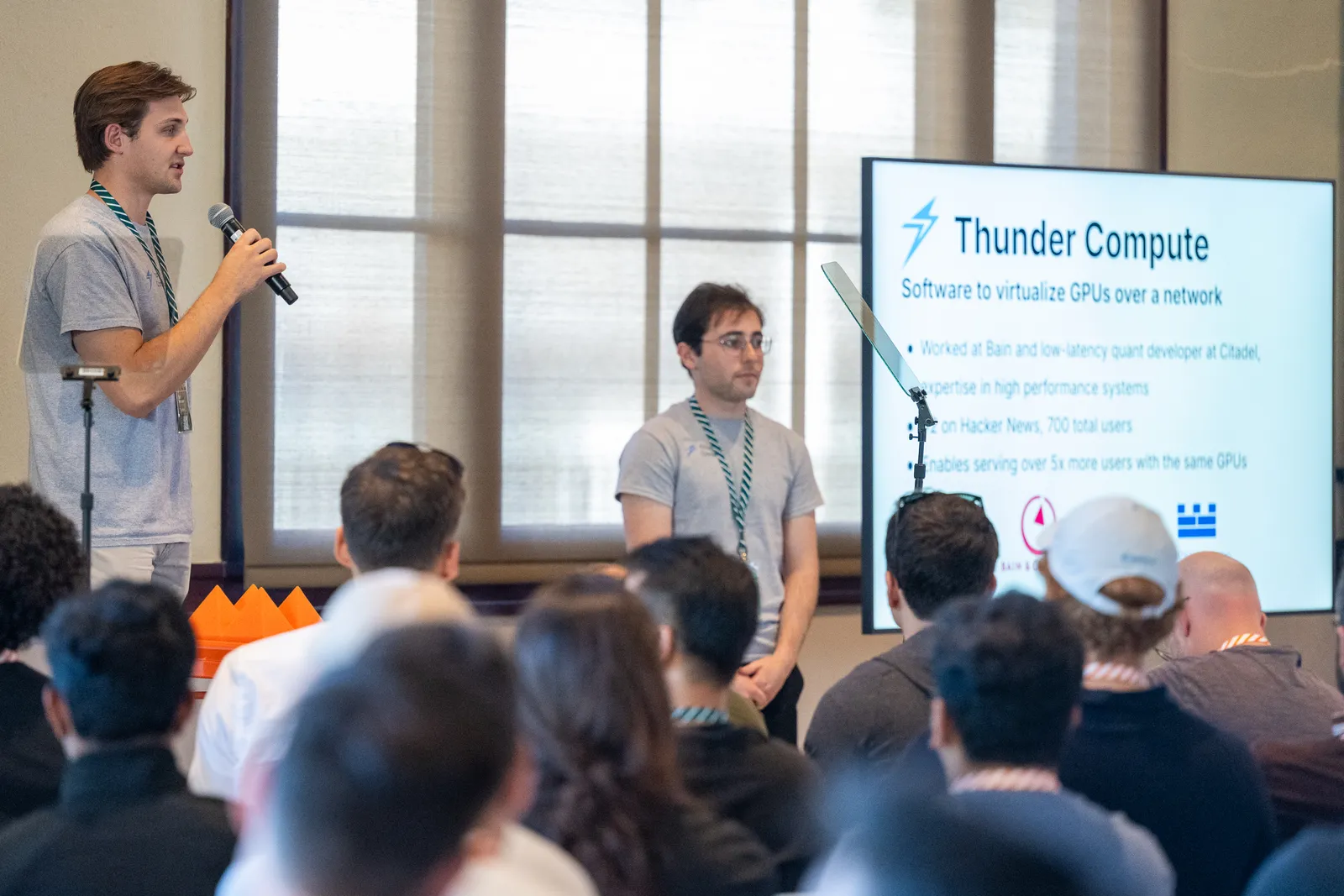 Two of the Thunder Compute team presenting the company on stage